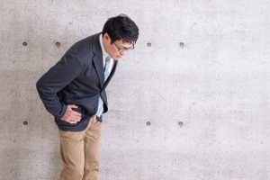 骨盤を押さえて悩んでいる様子
