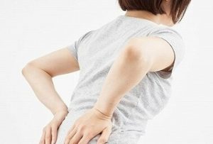 腰痛で腰を押さえている様子