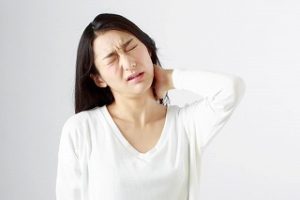 苦悶の表情で首を押さえている様子